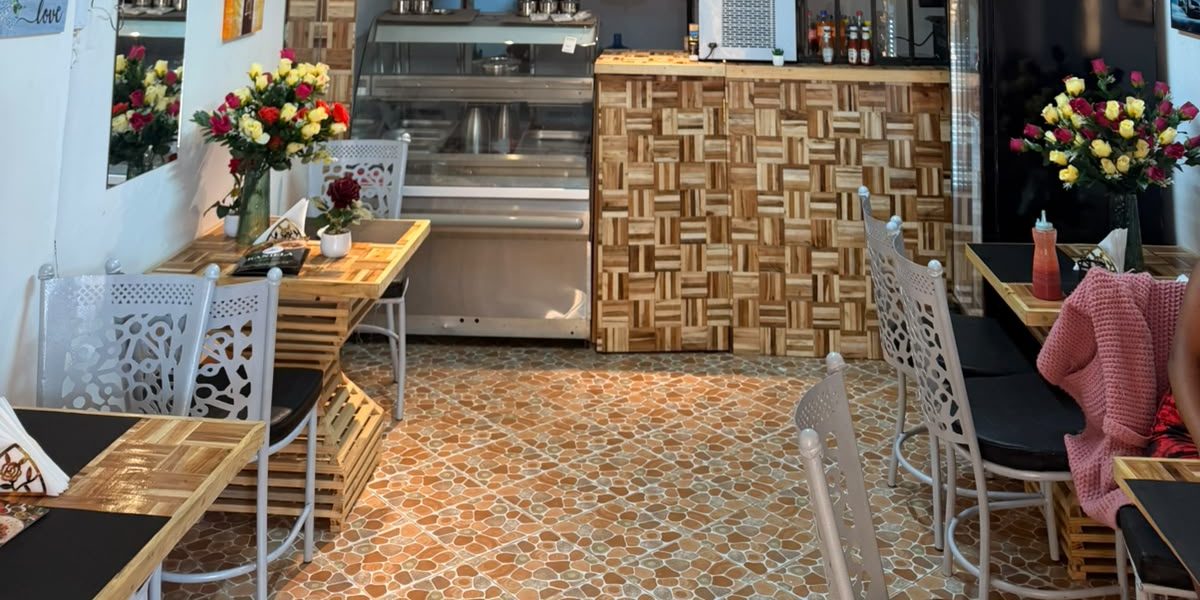 Kaniella dining area with wooden tables, flower arrangements and the serving counter